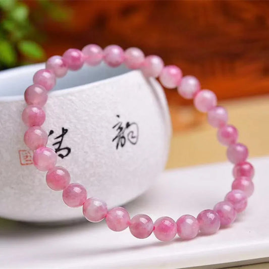 A delicate pink tourmaline bracelet featuring smooth round beads, exuding calming and serene energy